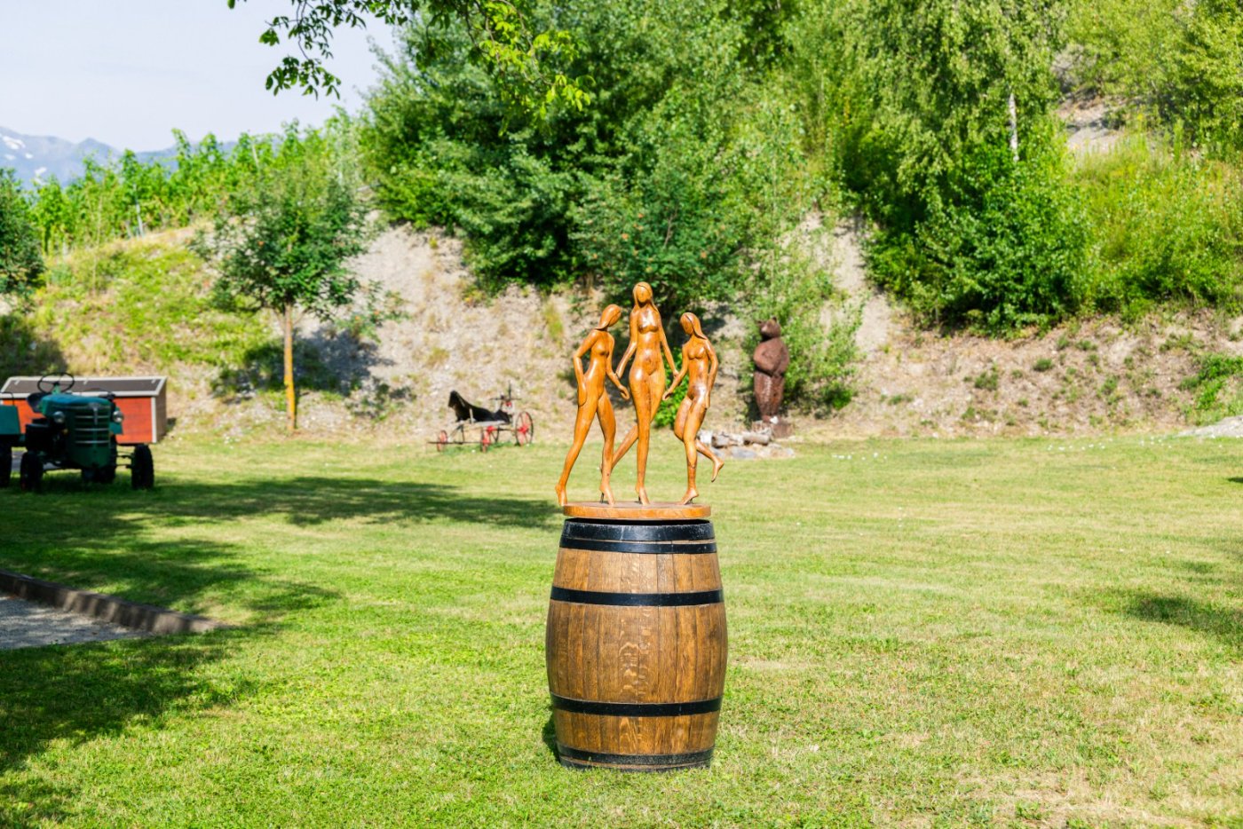 La sculpture des trois Muses sur une barrique, dans le jardin du domaine